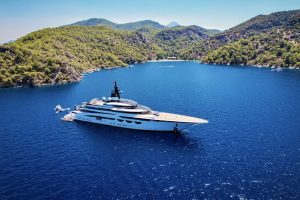 Majestic super yacht with an array of water toys spread on the blue waters of a secluded Caribbean bay. Watertoys available through Ocean Premium's luxury water toy rentals.